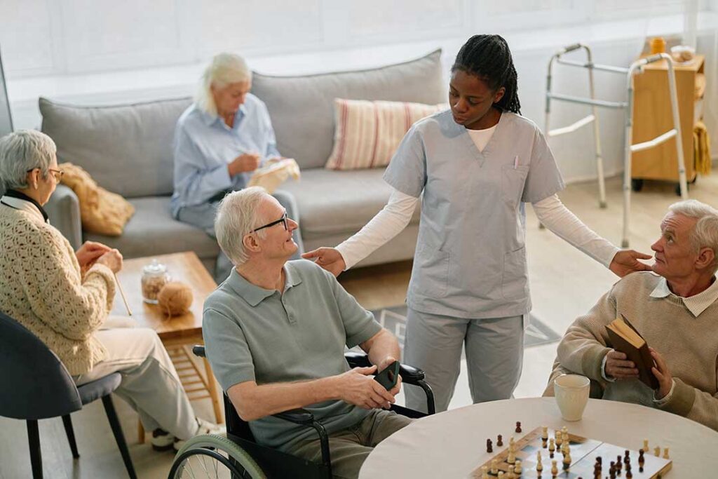 Family members review care documents with an assisted living resident at a dining table.