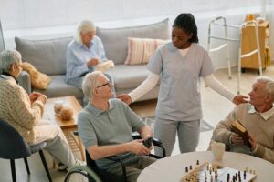 Family members review care documents with an assisted living resident at a dining table.